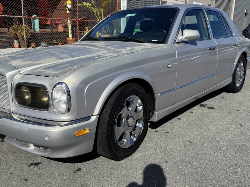 A silver Bentley Arnage saloon parked outside the shop.
